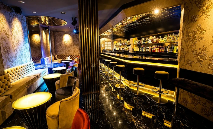 Elegant interior of Darling Club Barcelona with illuminated bar, lounge seating and showgirls stage area